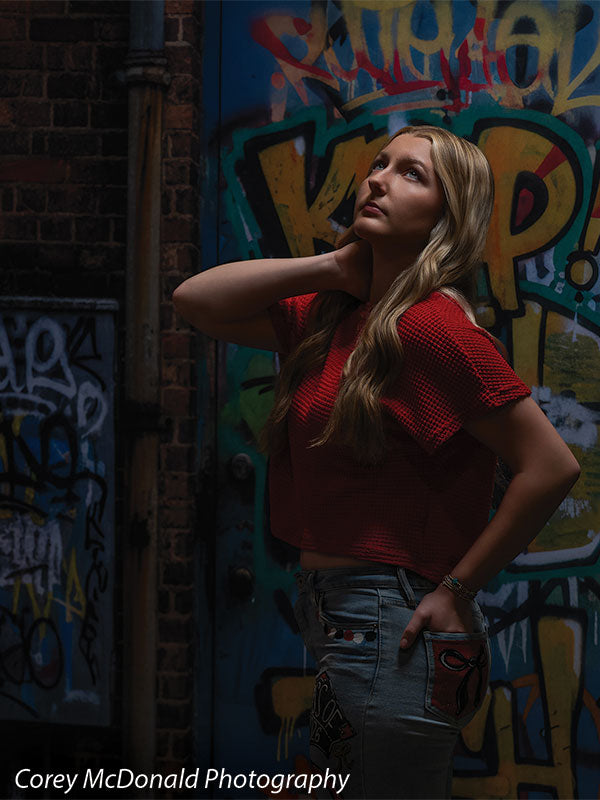 Keaton Graffiti Warehouse Door, photography backdrop panel for Denny StudioEdge silicone edge frame, shown with a senior girl in a red top looking upward with a hand behind her neck SECP-8864