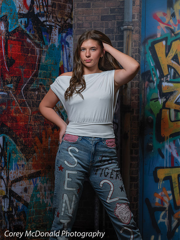 Keaton Graffiti Warehouse Door, photography backdrop panel for Denny StudioEdge silicone edge frame, shown with a senior girl in a white top with a hand in her hair SECP-8864
