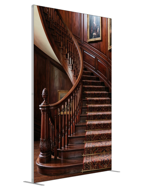 A mahogany curved staircase with turned balusters, a patterned runner and paneled walls hung with portraits, 5ft photography backdrop panel for Denny StudioEdge silicone edge frame, angled view