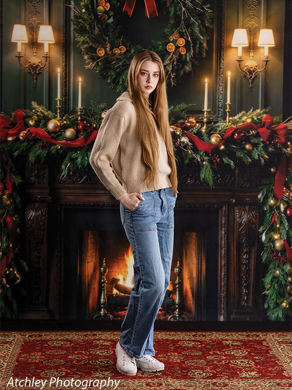 Manor Hearth dark wood fireplace with Christmas wreath photography backdrop shown with a senior girl in a tan sweater and jeans standing with a hand in her pocket CP-8885