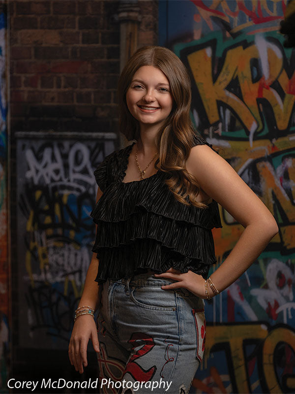 Marlowe Brick Wall Graffiti, photography backdrop panel for Denny StudioEdge silicone edge frame, shown with a senior girl in a black ruffle top smiling with a hand on her hip SECP-8863