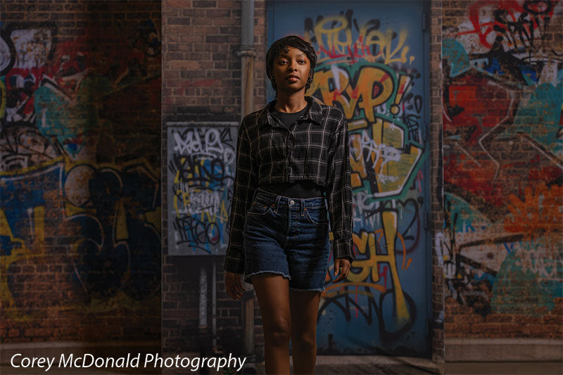 Marlowe Brick Wall Graffiti, photography backdrop panel for Denny StudioEdge silicone edge frame, shown with a senior girl standing full-length centered on the graffiti wall SECP-8863