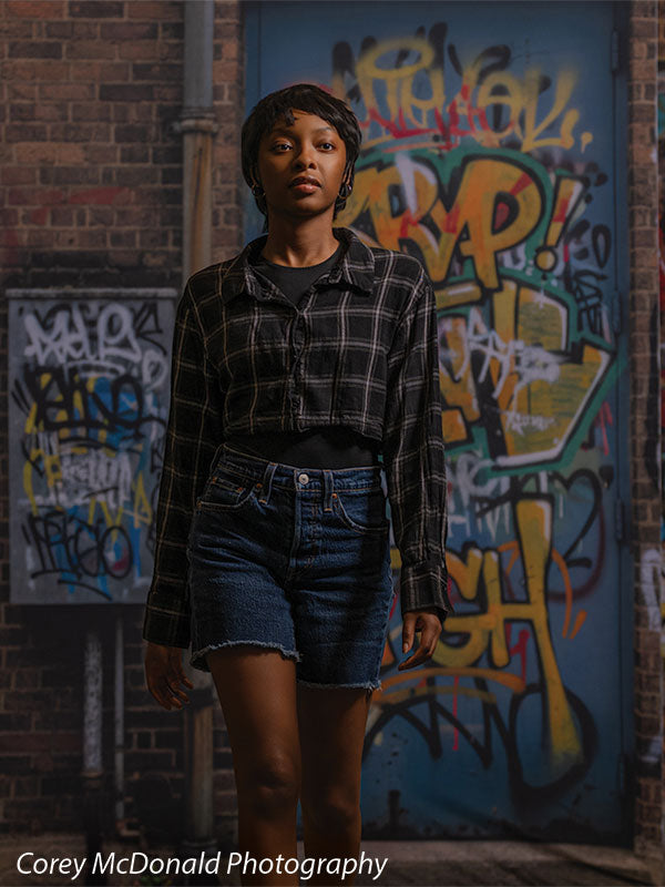 Marlowe Brick Wall Graffiti, photography backdrop panel for Denny StudioEdge silicone edge frame, shown with a senior girl standing centered against the graffiti wall, half-length SECP-8863