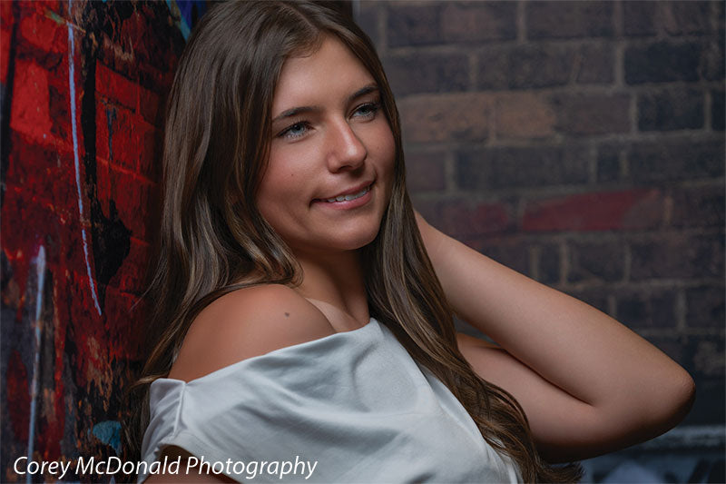 Marlowe Brick Wall Graffiti, photography backdrop panel for Denny StudioEdge silicone edge frame, shown with a senior girl in a close portrait with a hand in her hair SECP-8863