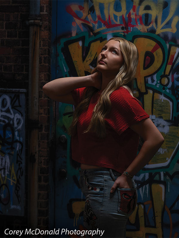 Marlowe Brick Wall Graffiti, photography backdrop panel for Denny StudioEdge silicone edge frame, shown with a senior girl in a red top looking upward with a hand behind her neck SECP-8863