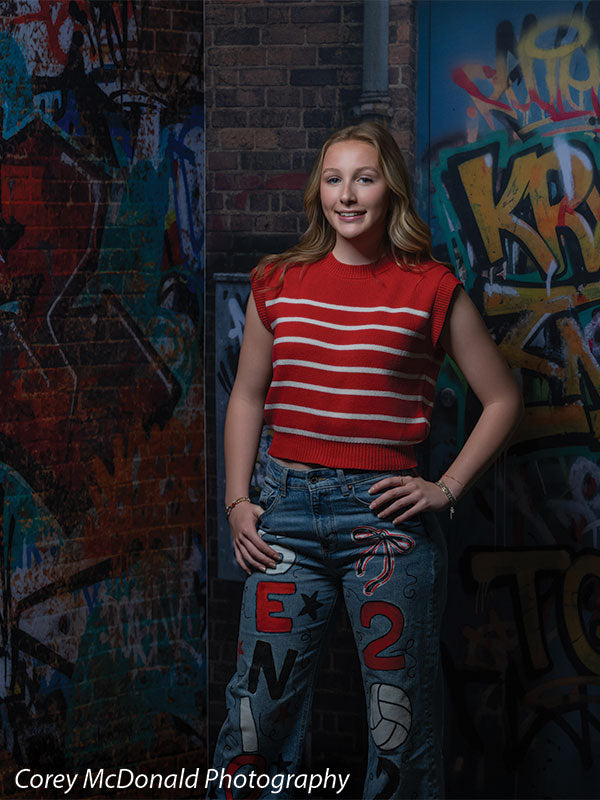 Marlowe Brick Wall Graffiti, photography backdrop panel for Denny StudioEdge silicone edge frame, shown with a senior girl in a red striped top and painted jeans with a hand on her hip SECP-8863