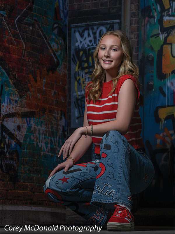 Marlowe Brick Wall Graffiti, photography backdrop panel for Denny StudioEdge silicone edge frame, shown with a senior girl in a red striped top kneeling on one knee SECP-8863