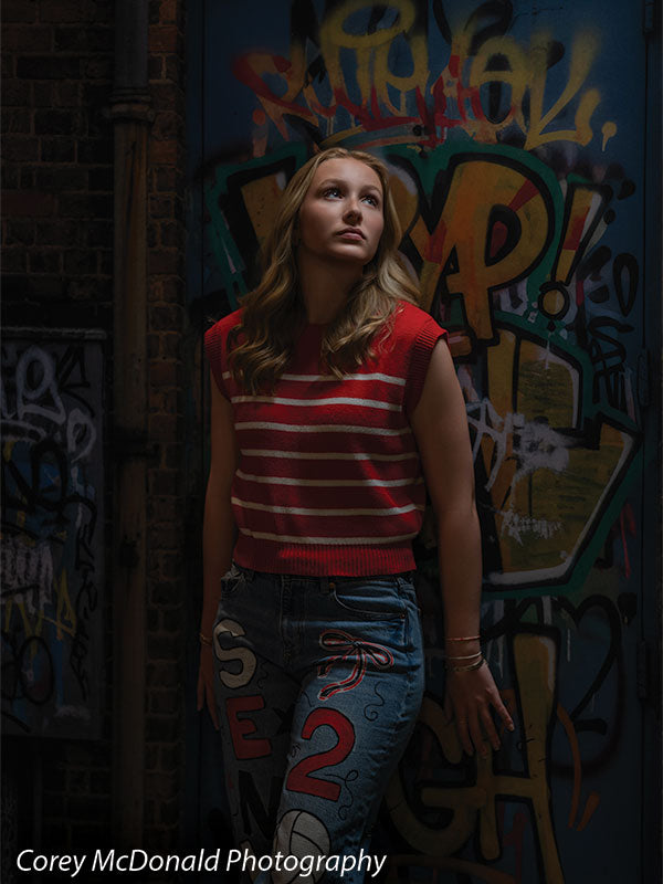 Marlowe Brick Wall Graffiti, photography backdrop panel for Denny StudioEdge silicone edge frame, shown with a senior girl in a red striped top standing and looking upward SECP-8863