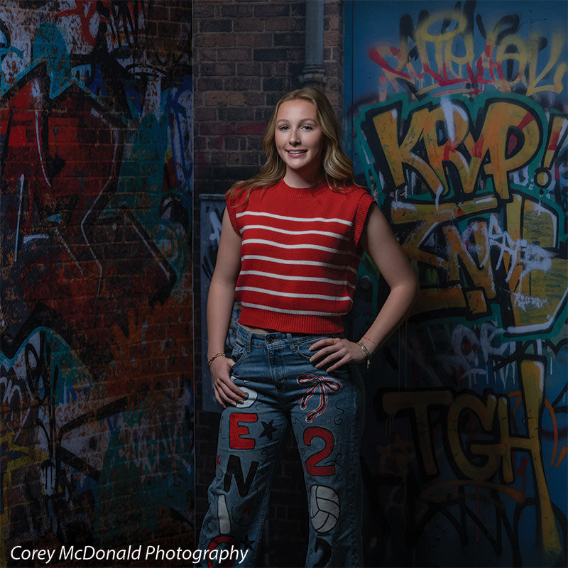 Marlowe Brick Wall Graffiti, photography backdrop panel for Denny StudioEdge silicone edge frame, shown with a senior girl in a red striped top standing against the graffiti wall SECP-8863