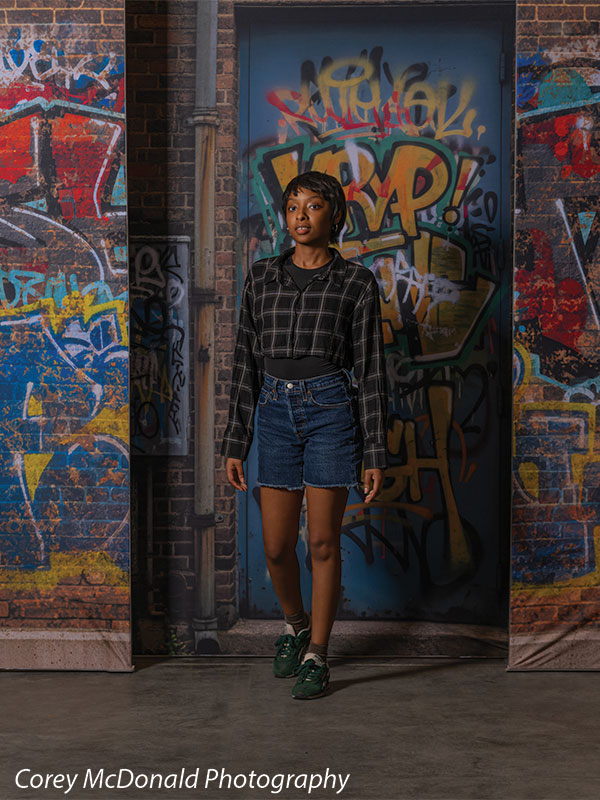 Marlowe Brick Wall Graffiti, photography backdrop panel for Denny StudioEdge silicone edge frame, shown with a senior girl standing in front of the graffiti wall, full-length SECP-8863