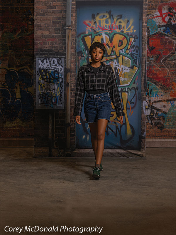 Marlowe Brick Wall Graffiti, photography backdrop panel for Denny StudioEdge silicone edge frame, shown with a senior girl walking forward past the graffiti wall, full-length SECP-8863