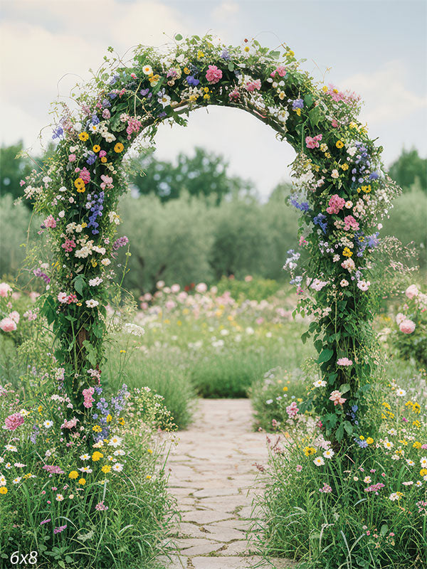 A graceful arch of colorful blossoms and vines rises over a winding garden path surrounded by lush meadow flowers.