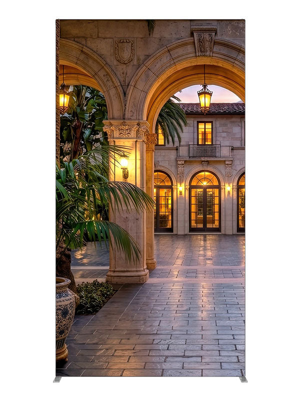 Grand stone archways opening onto a lantern-lit Mediterranean villa courtyard at dusk, 4ft photography backdrop panel for Denny StudioEdge silicone edge frame