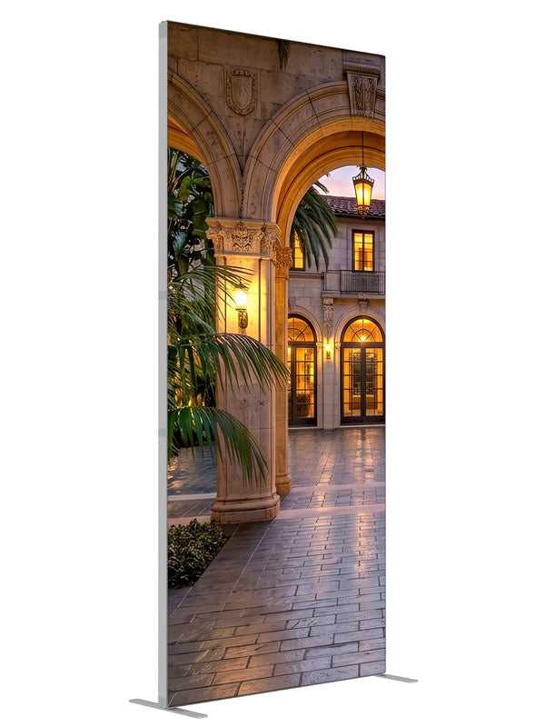 Grand stone archways opening onto a lantern-lit Mediterranean villa courtyard at dusk, 3ft photography backdrop panel for Denny StudioEdge silicone edge frame, angled view