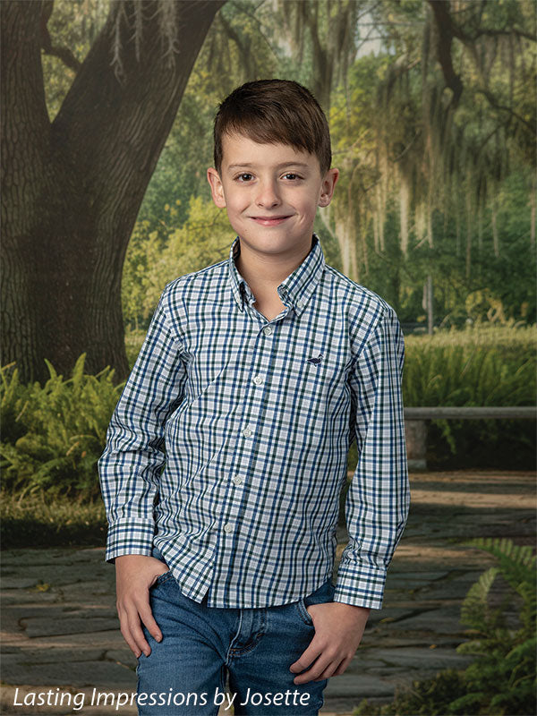 Moss Oak photography backdrop showing a grand Southern live oak draped in Spanish moss over a stone garden path, shown with a young boy in a blue plaid button-down with hands in his pockets CP-8783