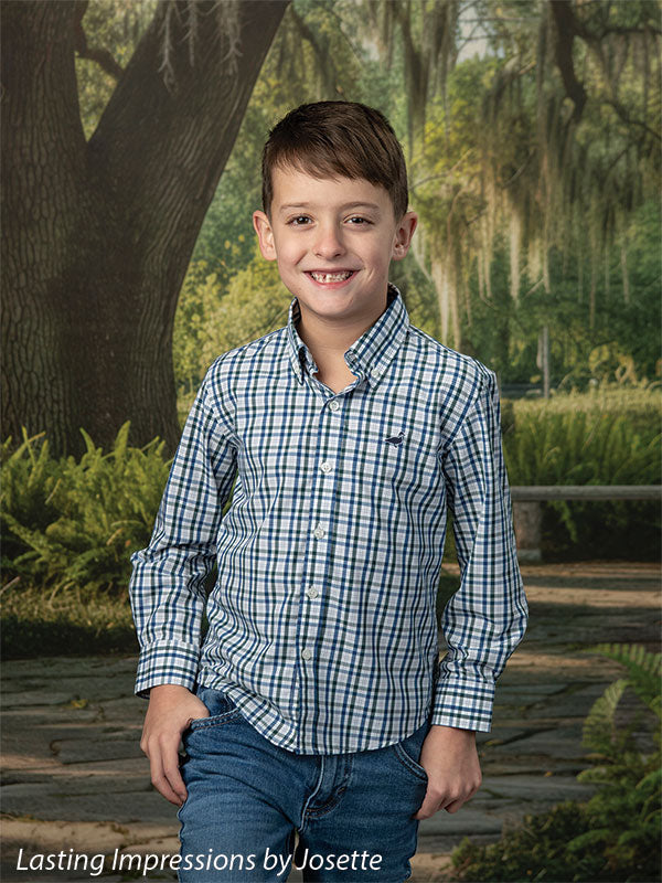 Moss Oak photography backdrop showing a grand Southern live oak draped in Spanish moss over a stone garden path, shown with a young boy in a blue and white plaid shirt smiling with a hand in his pocket CP-8783