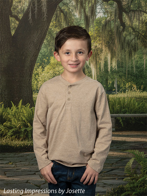 Moss Oak photography backdrop showing a grand Southern live oak draped in Spanish moss over a stone garden path, shown with a young boy in a tan henley with a hand in his pocket CP-8783