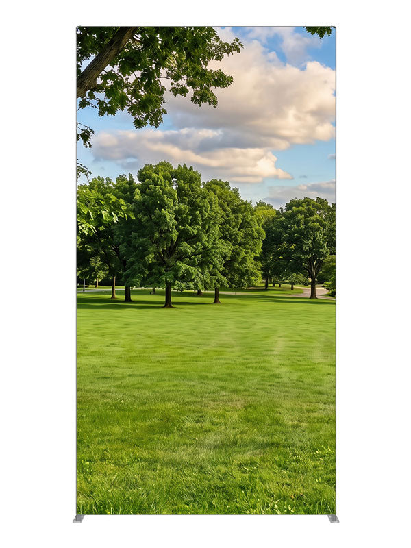 A broad open park lawn with a large shade tree and a distant tree line under a cloud-dotted sky, 4ft photography backdrop panel for Denny StudioEdge silicone edge frame