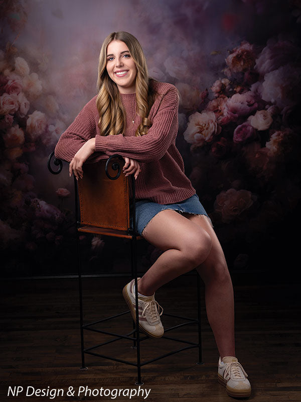 Peonies and roses photography backdrop shown with a senior girl in a mauve sweater and denim skirt seated on a stool in a full-length pose CP-8491