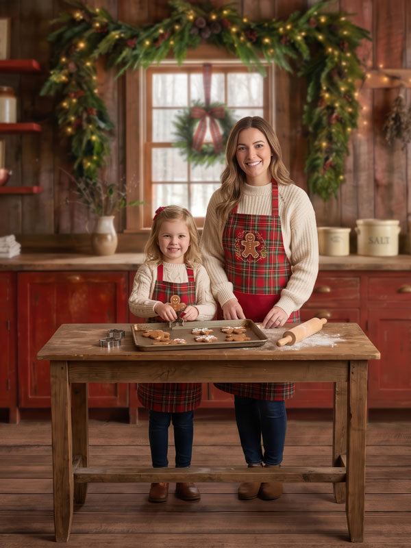 Red Cabin rustic Christmas kitchen with red cabinets photography backdrop shown with a mother and young daughter in matching aprons decorating cookies CP-8887