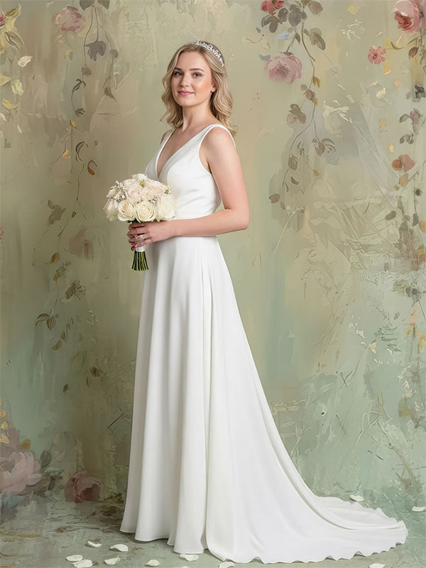 A bride in a white gown holds a bouquet while standing in front of a softly painted floral backdrop with muted green tones, delicate flowers, and an elegant textured finish.
