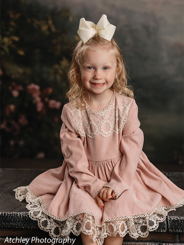 Rose Haze ethereal rose garden photography backdrop shown with a young girl in a dusty-pink lace dress seated on a brick riser, smiling CP-8958