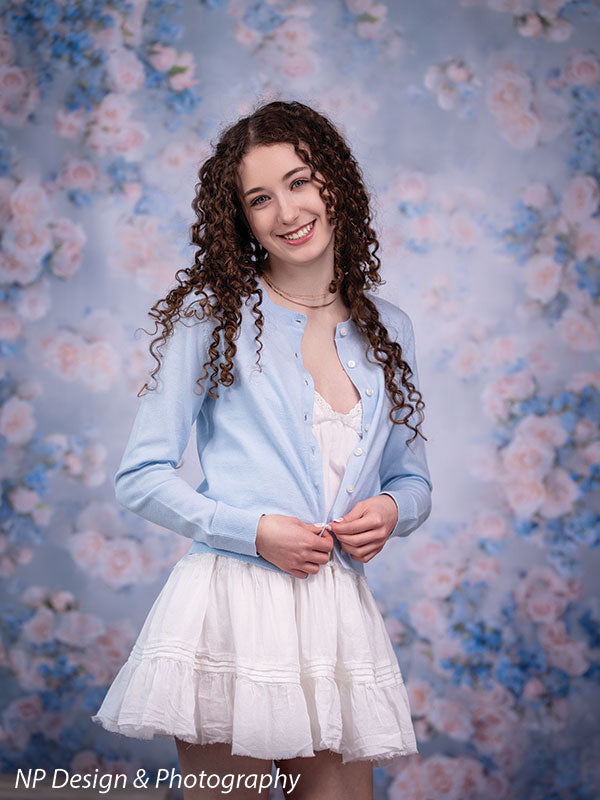 Rose master blue floral photography backdrop shown with standing with her blue cardigan open over a white dress, smiling CP-7598