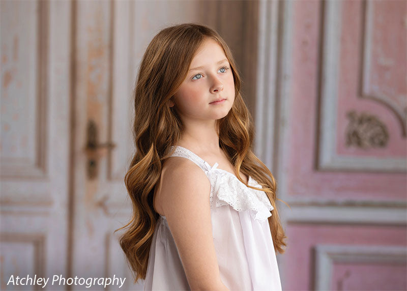 Rose Parlor distressed pink French double doors photography backdrop shown with a young girl in a white slip dress in a half-length portrait CP-8793