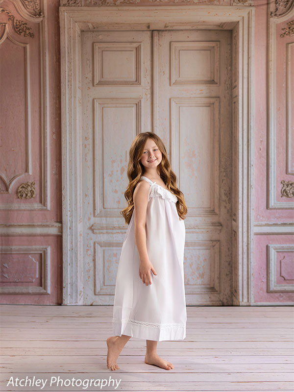 Rose Parlor distressed pink French double doors photography backdrop shown with a young girl in a white slip dress looking down CP-8793