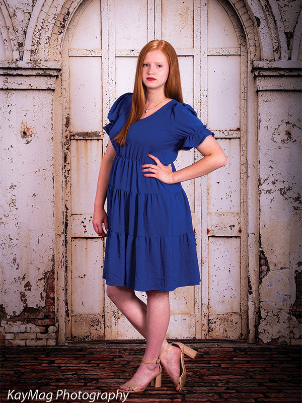 Rustic red brick floor photography backdrop paired with distressed white arched doors, creating a vintage urban setting for senior portraits.