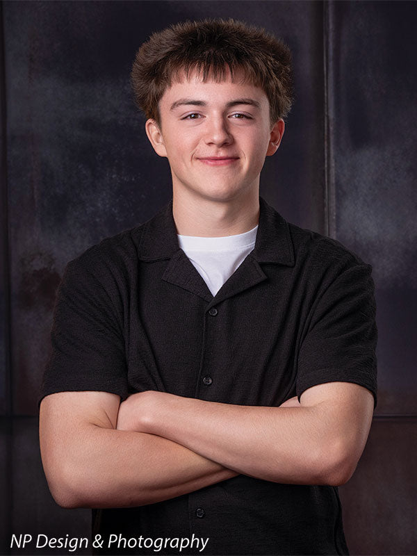 Rustic industrial metal panels photography backdrop shown with a senior boy with his arms crossed in a close portrait CP-8431