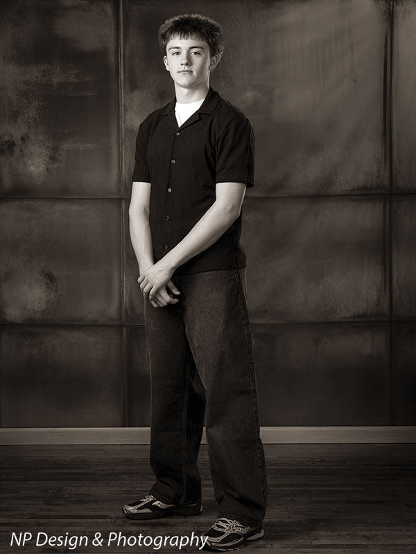 Rustic industrial metal panels photography backdrop shown with a senior boy standing full length in a black-and-white toned image CP-8431