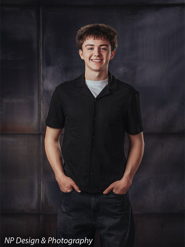 Rustic industrial metal panels photography backdrop shown with a senior boy standing with his hands in his pockets, smiling CP-8431
