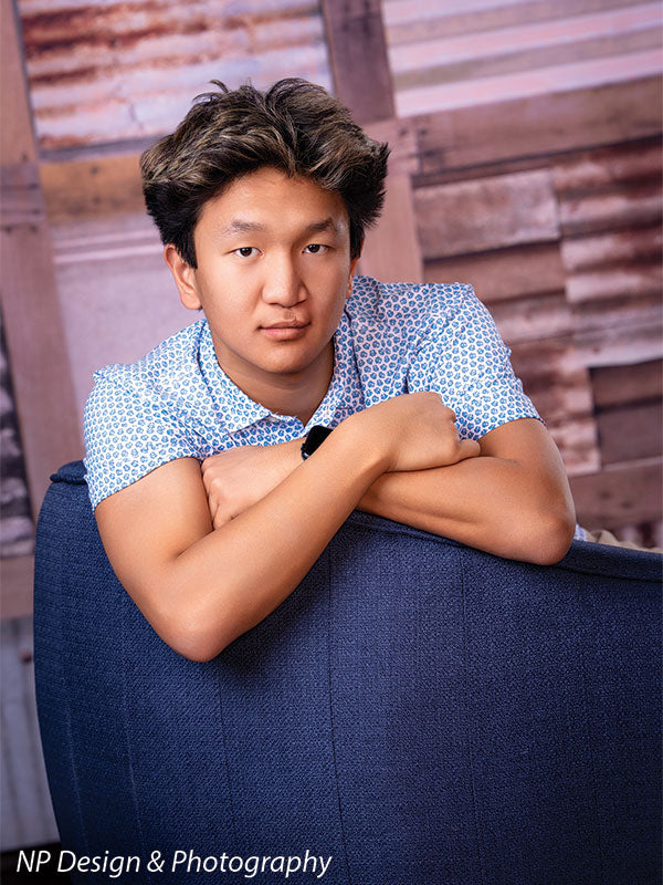 Rustic metal squares photography backdrop shown with a senior boy in a blue polo seated in a navy chair with arms crossed CP-7630