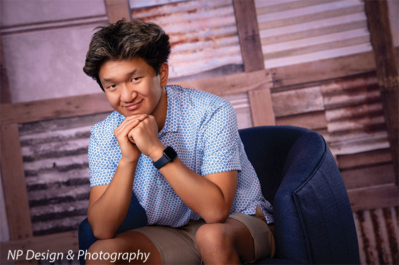 Rustic metal squares photography backdrop shown with a senior boy seated in a navy chair with hands under his chin CP-7630