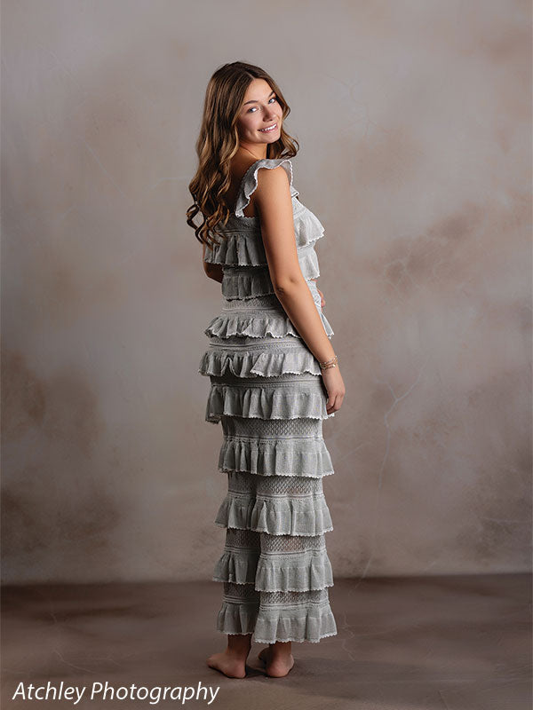 Sand Plaster warm cream plaster texture photography backdrop shown with a senior girl in a sage-green ruffled dress posed in side profile CP-8762