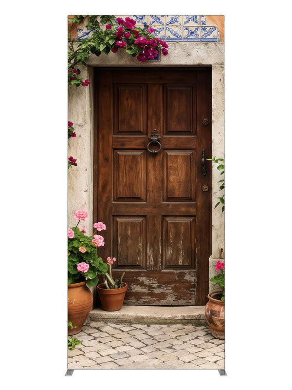 A carved wood door in a peach-terracotta Spanish facade with bougainvillea and potted geraniums, 3ft photography backdrop panel for Denny StudioEdge silicone edge frame