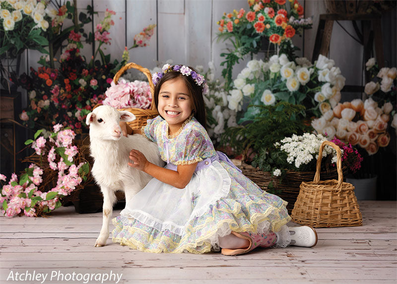 Children’s portrait backdrop with vibrant spring florals, a girl in pastel attire, and a lamb, designed for Easter or springtime photography sessions.