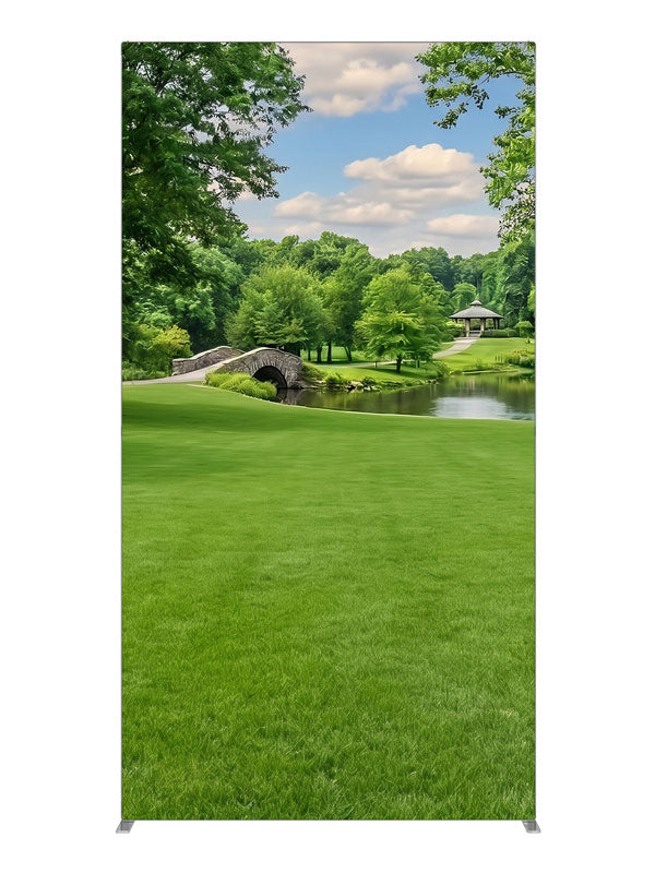 A groomed park lawn with a pond, arched stone bridge and a gazebo framed by trees, 4ft photography backdrop panel for Denny StudioEdge silicone edge frame
