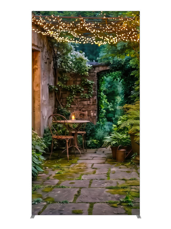 A garden courtyard at dusk under a pergola strung with warm fairy lights, with a bistro table and ferns, 4ft photography backdrop panel for Denny StudioEdge silicone edge frame