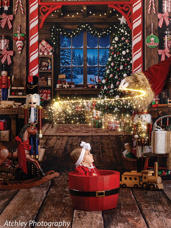 Sugar Workshop Santa's workshop interior photography backdrop shown with a baby in a red Santa bucket watching a trail of fairy-light sparkle CP-8910