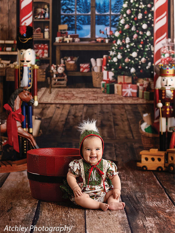 Sugar Workshop Santa's workshop interior photography backdrop shown with a baby in a gingerbread-print outfit and green hat seated in a red bucket CP-8910