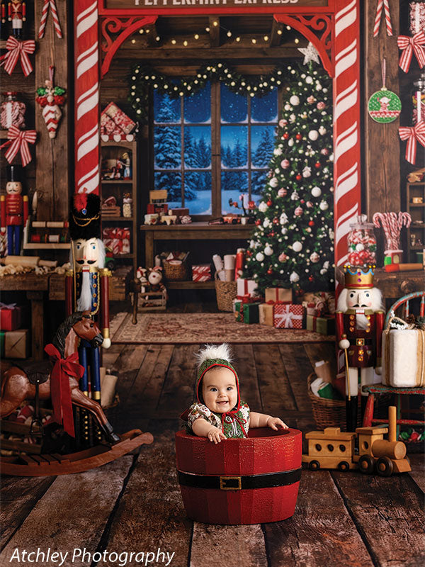 Sugar Workshop Santa's workshop interior photography backdrop shown with a baby in a gingerbread outfit sitting inside a red Santa-belt bucket CP-8910