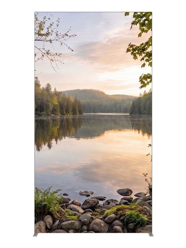Still forest lake at sunrise with a mirrored peach sky and a mossy stone shoreline, 4ft photography backdrop panel for Denny StudioEdge silicone edge frame