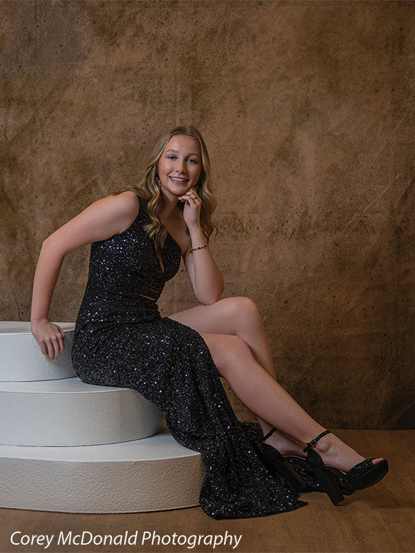 Textured Gold Radiance printed photography backdrop shown in a styled studio session with a senior in a black sequin gown seated on white posing steps, hand near her chin, smiling OM-2606