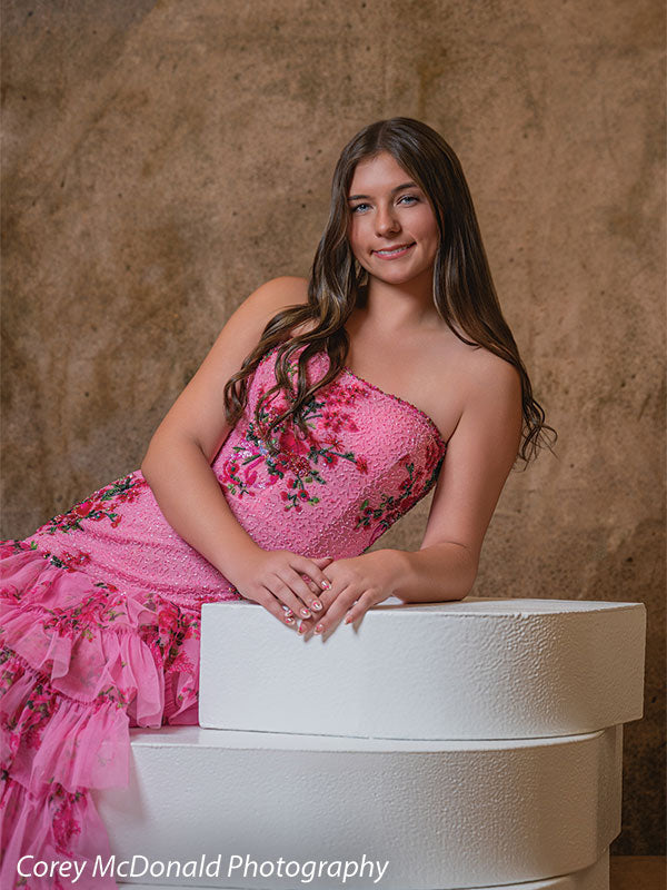 Textured Gold Radiance printed photography backdrop shown in a styled studio session with a senior in a pink floral gown leaning on a white posing step and smiling OM-2606