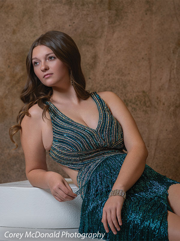 Textured Gold Radiance printed photography backdrop shown in a styled studio session with a senior in a teal fringed gown seated and leaning on a white posing step, gazing upward OM-2606