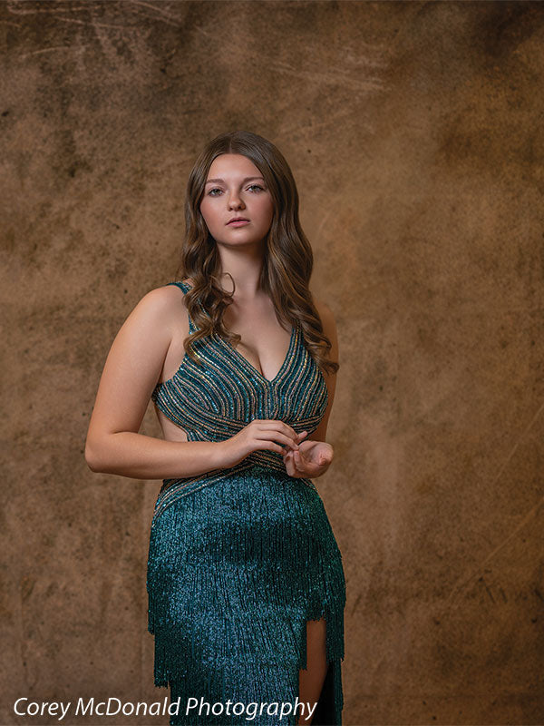 Textured Gold Radiance printed photography backdrop shown in a styled studio session with a senior in a teal fringed gown standing full-length with a poised expression OM-2606