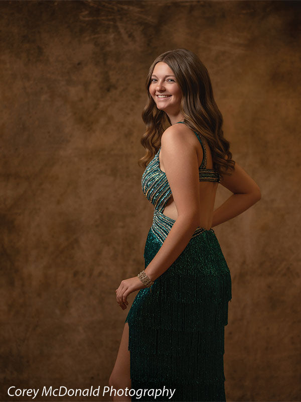 Textured Gold Radiance printed photography backdrop shown in a styled studio session with a senior in a teal fringed gown standing in side profile and smiling OM-2606