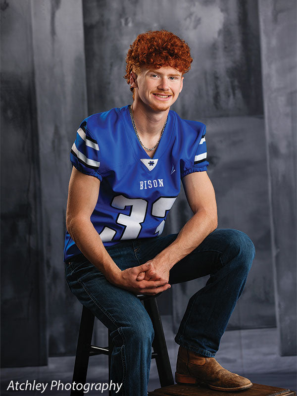Textured Gray multi-panel photography backdrop shown with a senior athlete in a blue football jersey seated on a stool CP-8817